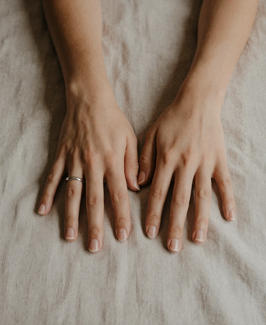 Two resting hands on linen sheets - chemistry-first intimate dating app imagery about presence rather than anatomy