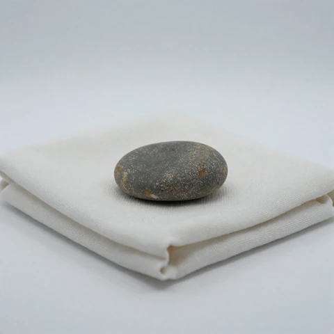 Smooth pebble on linen still life - companion image for overcoming fear of intimacy essay