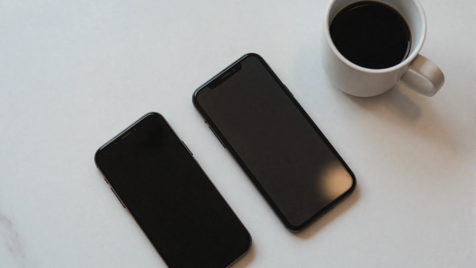 Two smartphones side by side on a minimal white table - a visual cue for comparing alternative dating apps